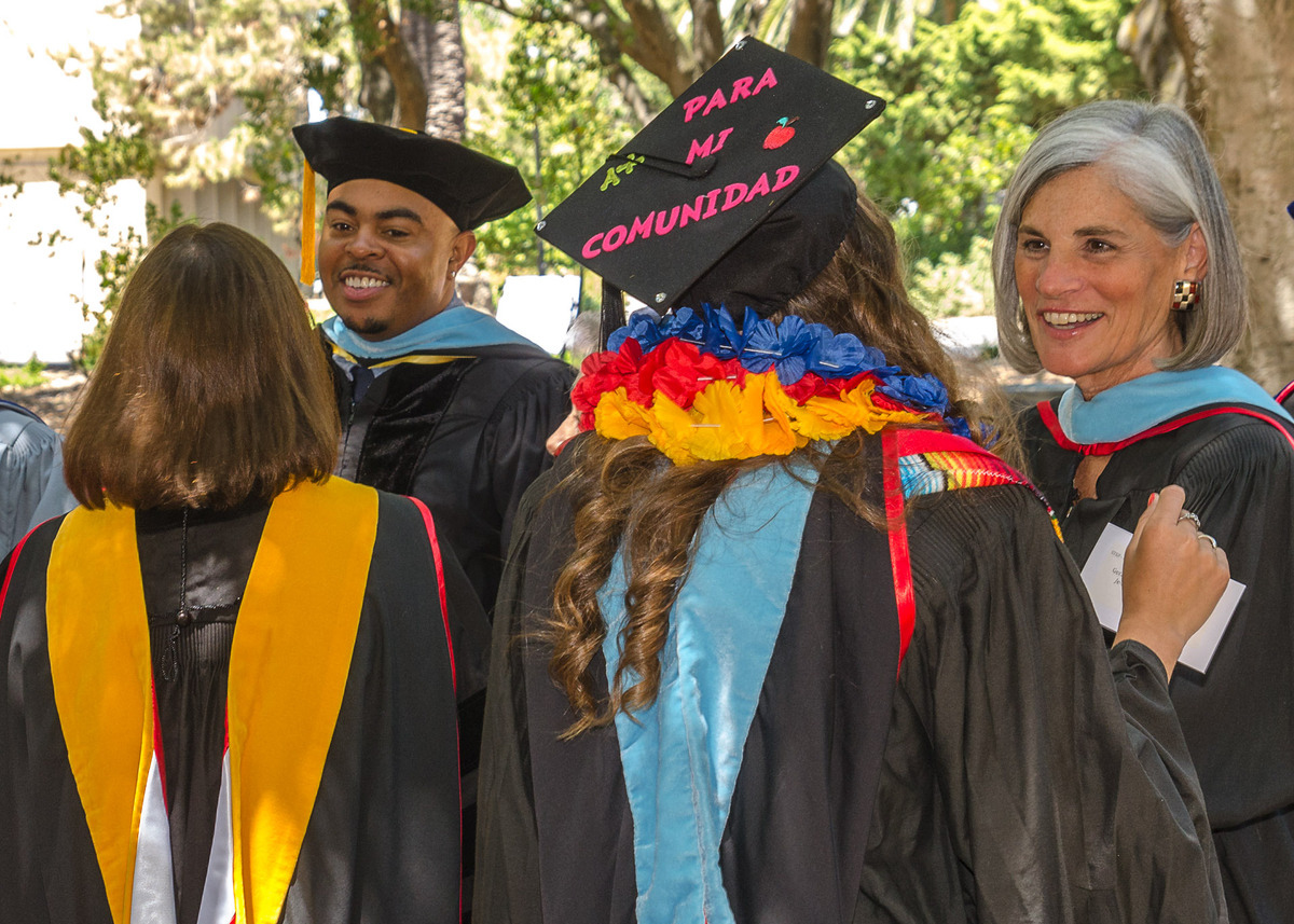 Graduates speaking with professors.