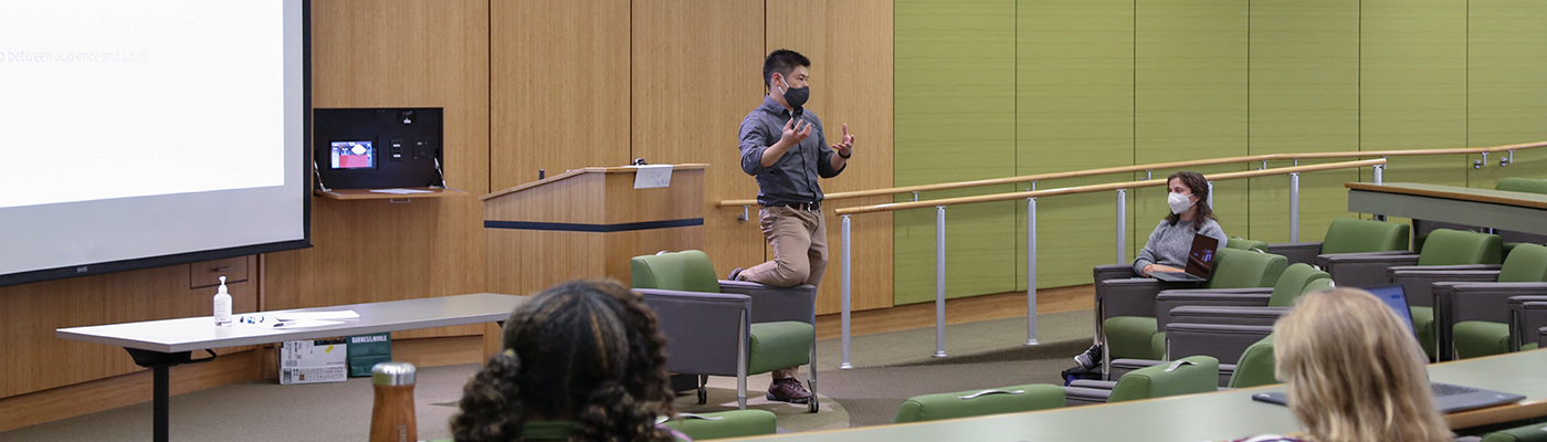 Picture of Victor Lee teaching in an auditorium