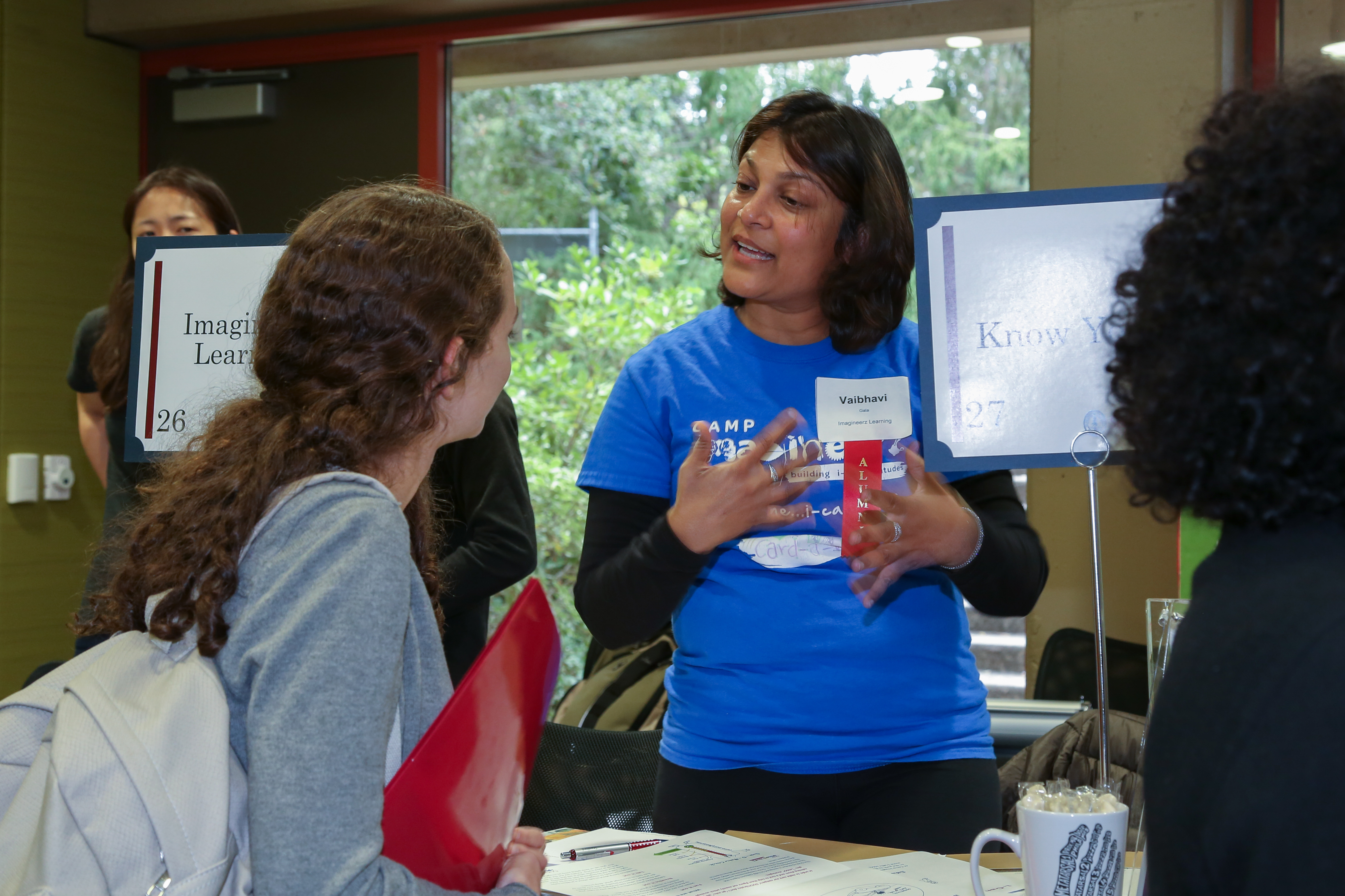 Attendee speaking to someone tabling at an event.