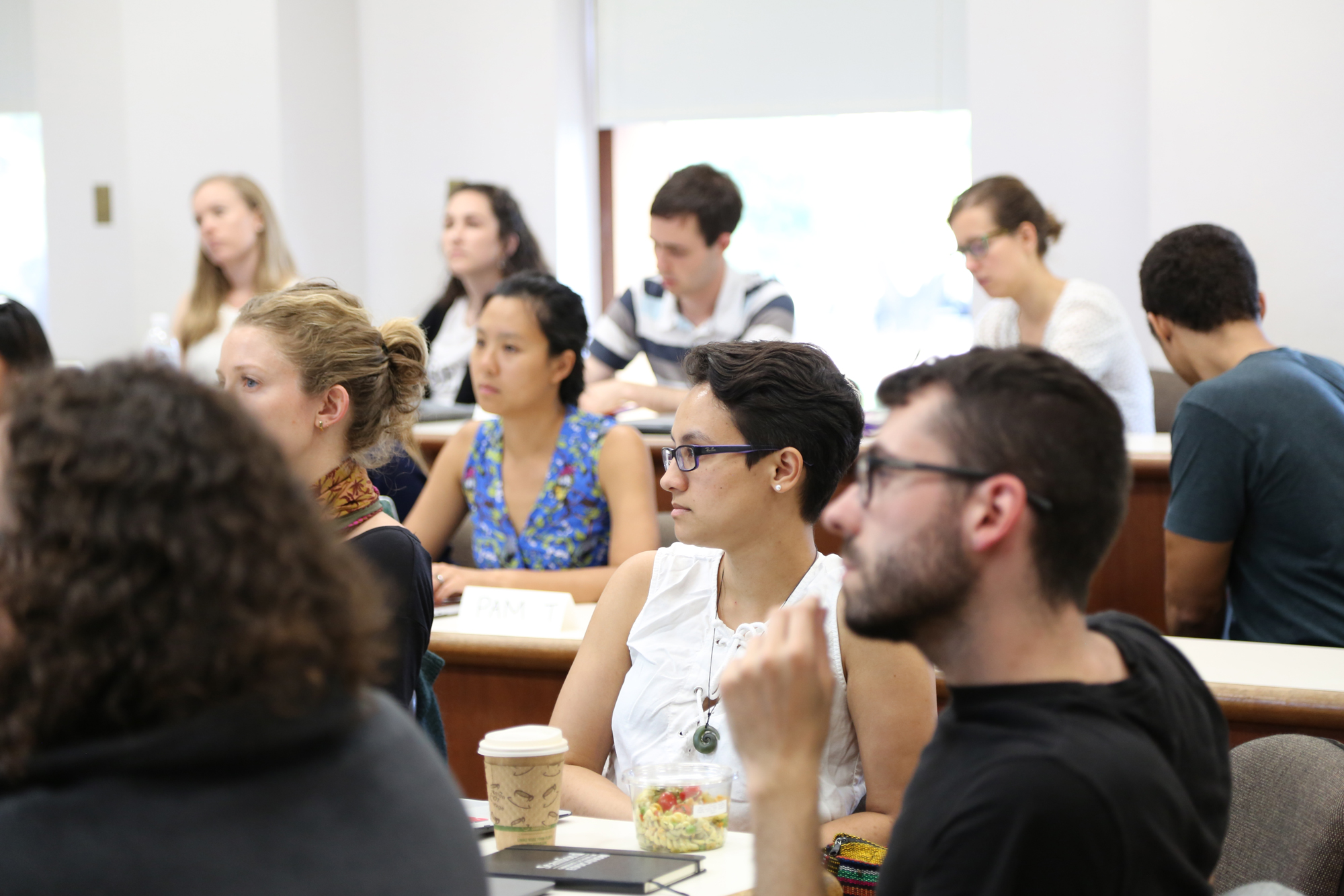 A group of people in a workshop looking in one direction.