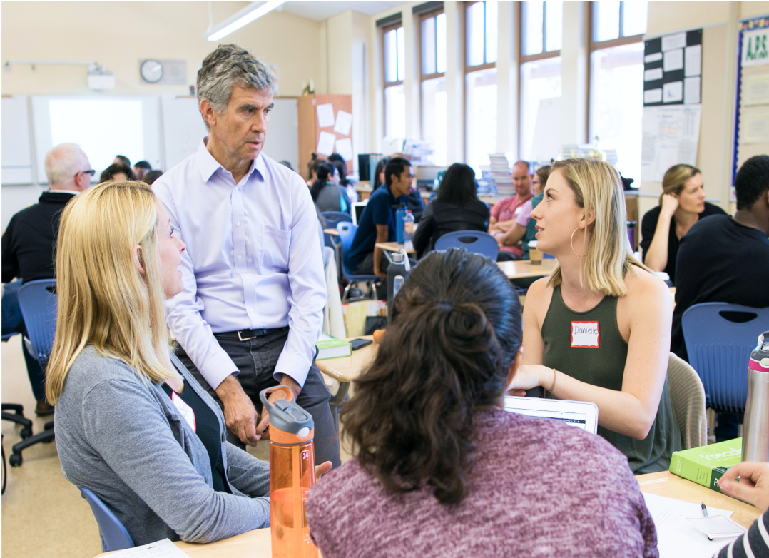 Dean Schwartz speaking to a group of attendees at a table.