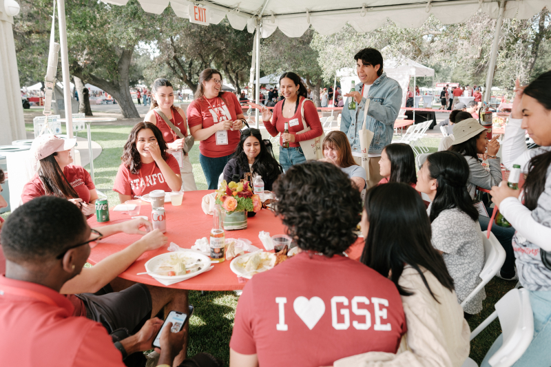 ALumni sitting around a table at 2024 tailgate