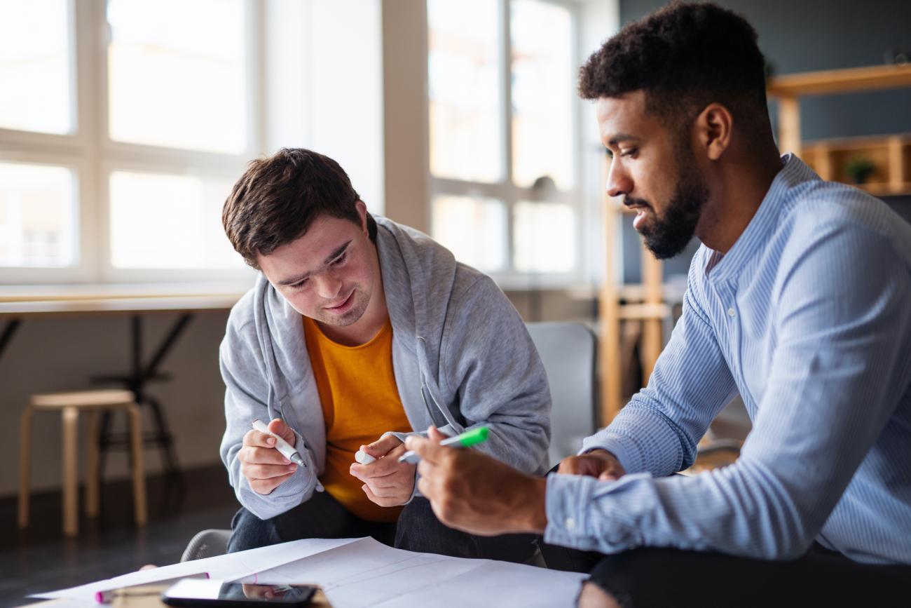 Student with Down syndrome reading with a tutor