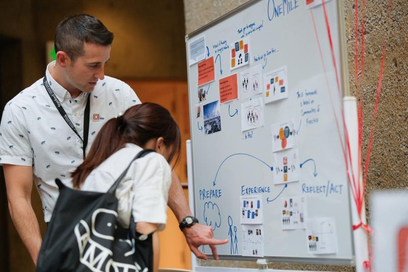 Joe Shook walks an attendee through OneMile, a project that helps teachers reimagine schooling with neurodiverse students at the center. (Photo: Ryan Zhang)