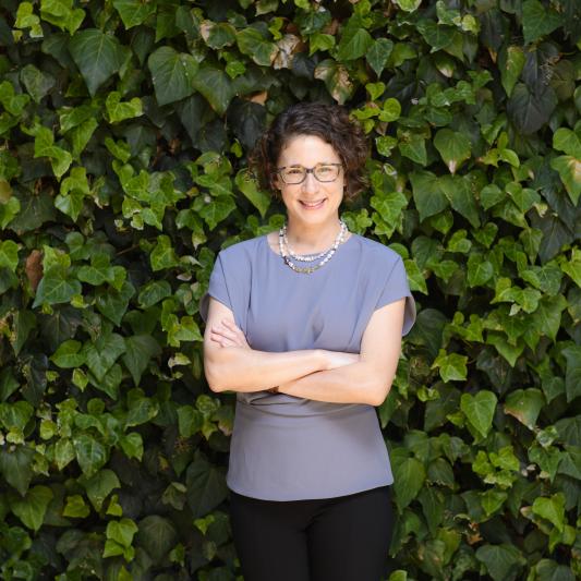 Associate Professor Emily J. Levine standing in front of a hedge of ivy