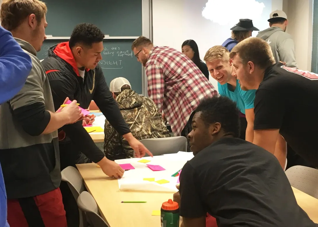 Students working on a poster around a table.