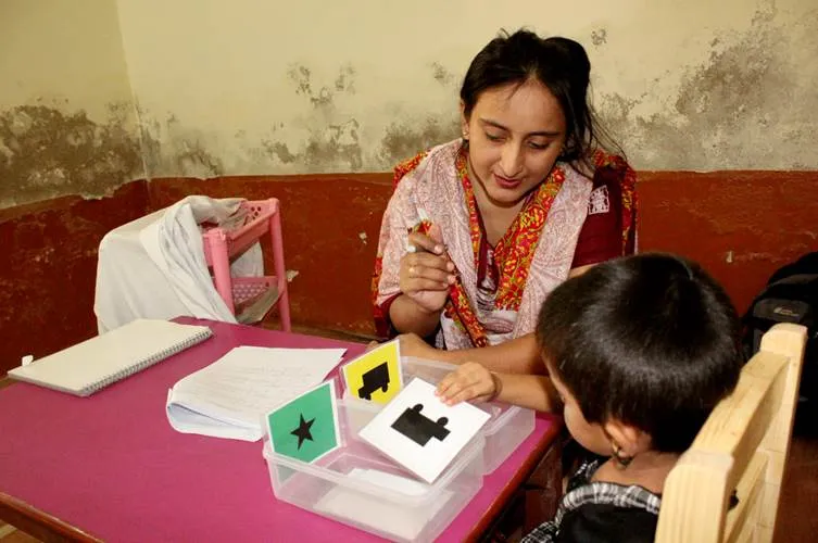 Assessor administers tests with preschooler in rural Pakistan