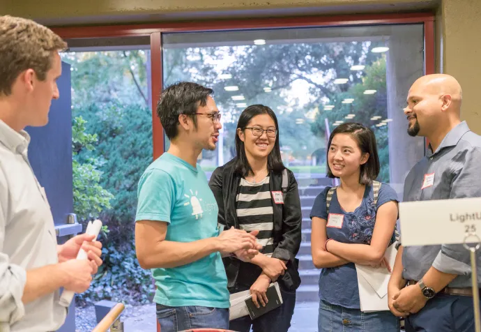 Group of students standing around and discussing.