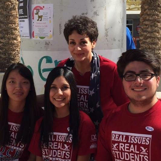 Haydee Rodriguez with two female and one male students.