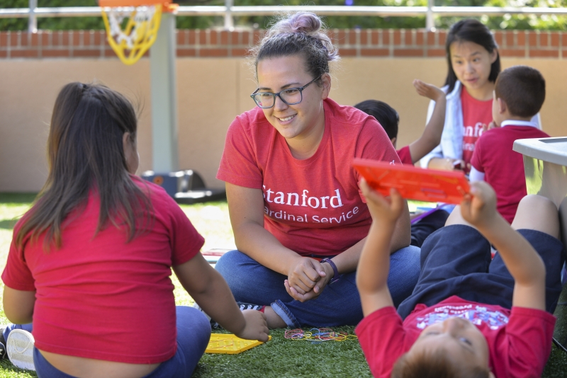A teacher in a playground with preschool students