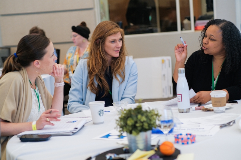 Three educators at a conference table