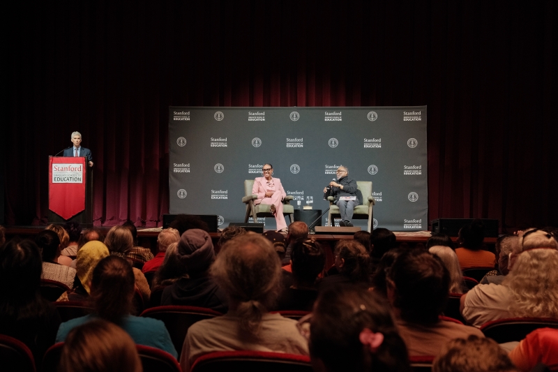 Dan Schwartz speaks from the podium while Maisha Winn and LeVar Burton look on.