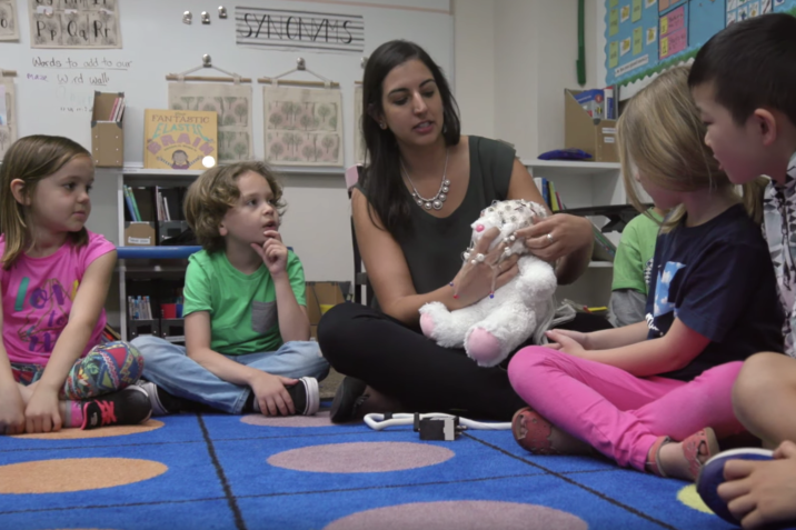 Picture of Elizabeth Toomarian teaching children about neuroscience with a stuffed bunny rabbit.