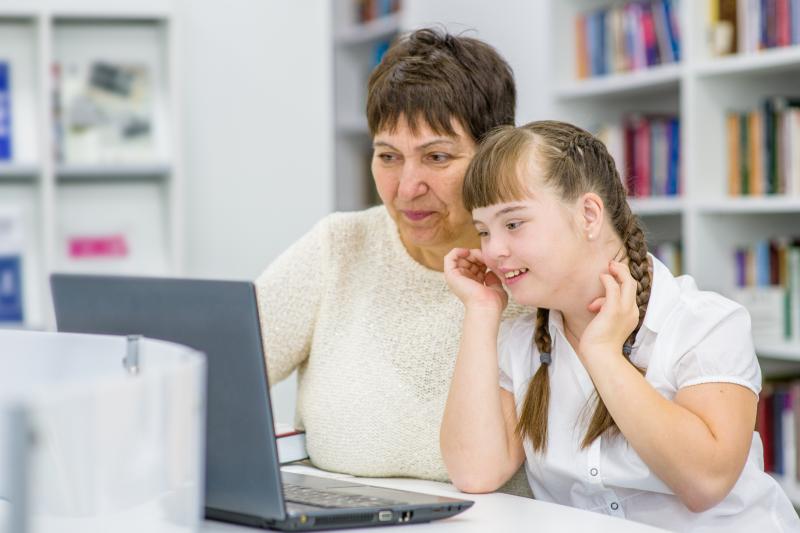 Photo of teacher with student who has Down syndrome