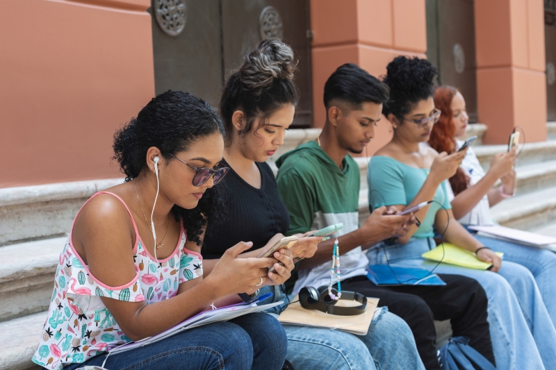 Brazilian teens on their phones outside of school