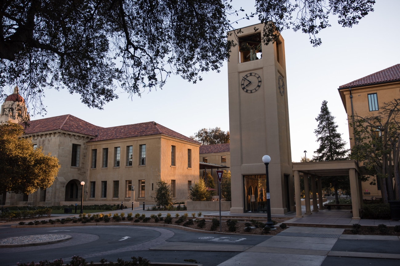 Picture of the GSE campus with the clock tower in the middle flanked by two buildings at sunset