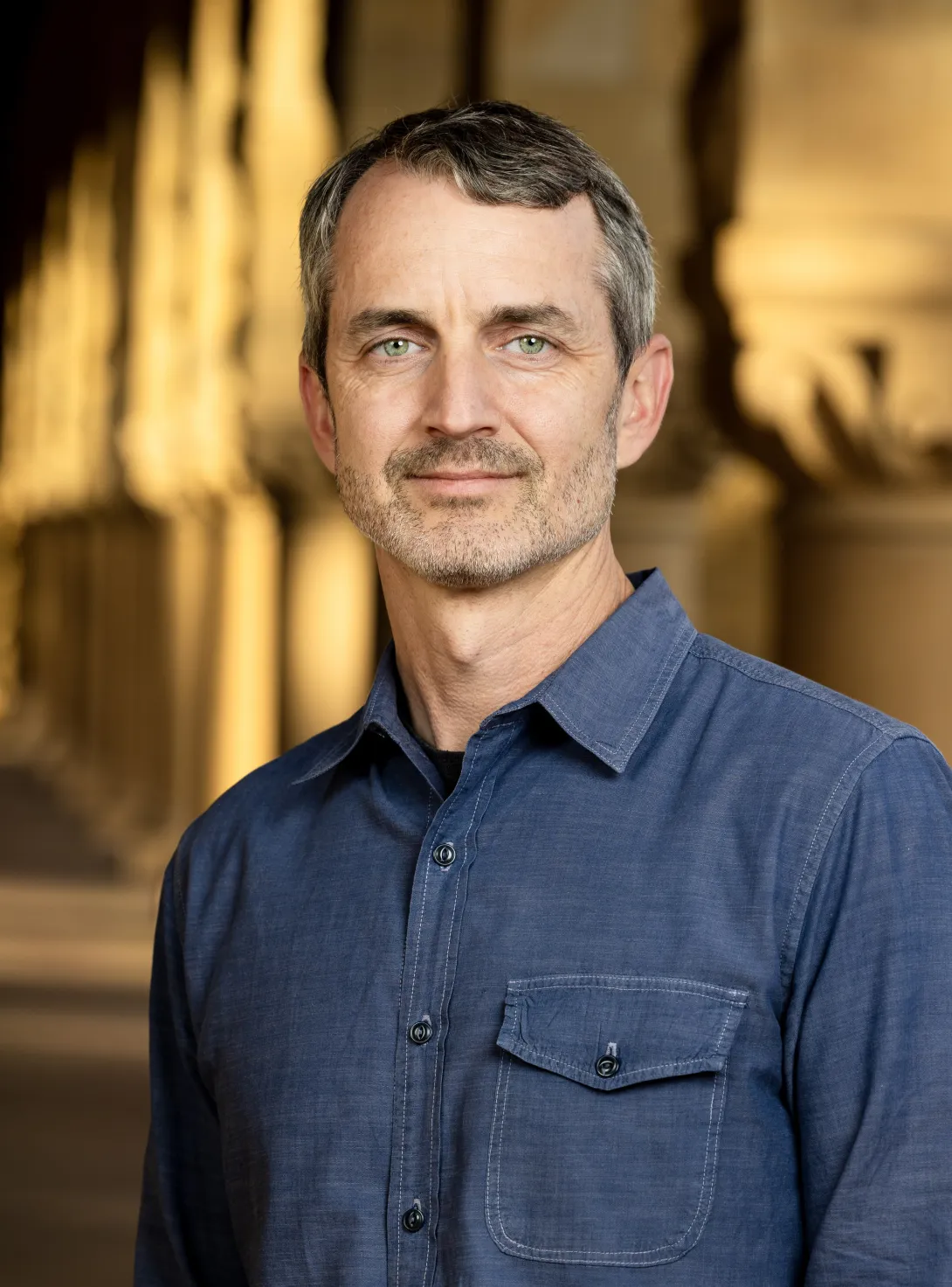 Professor Matthew Gentzkow in front of Stanford Quad arches