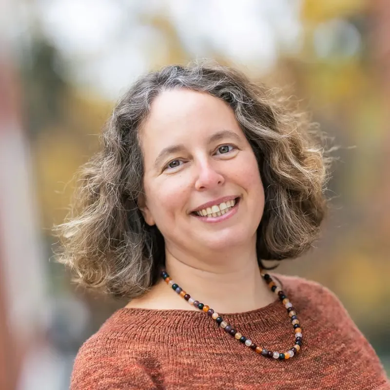 Picture of Meira Levinson outside wearing a necklace and orange sweater