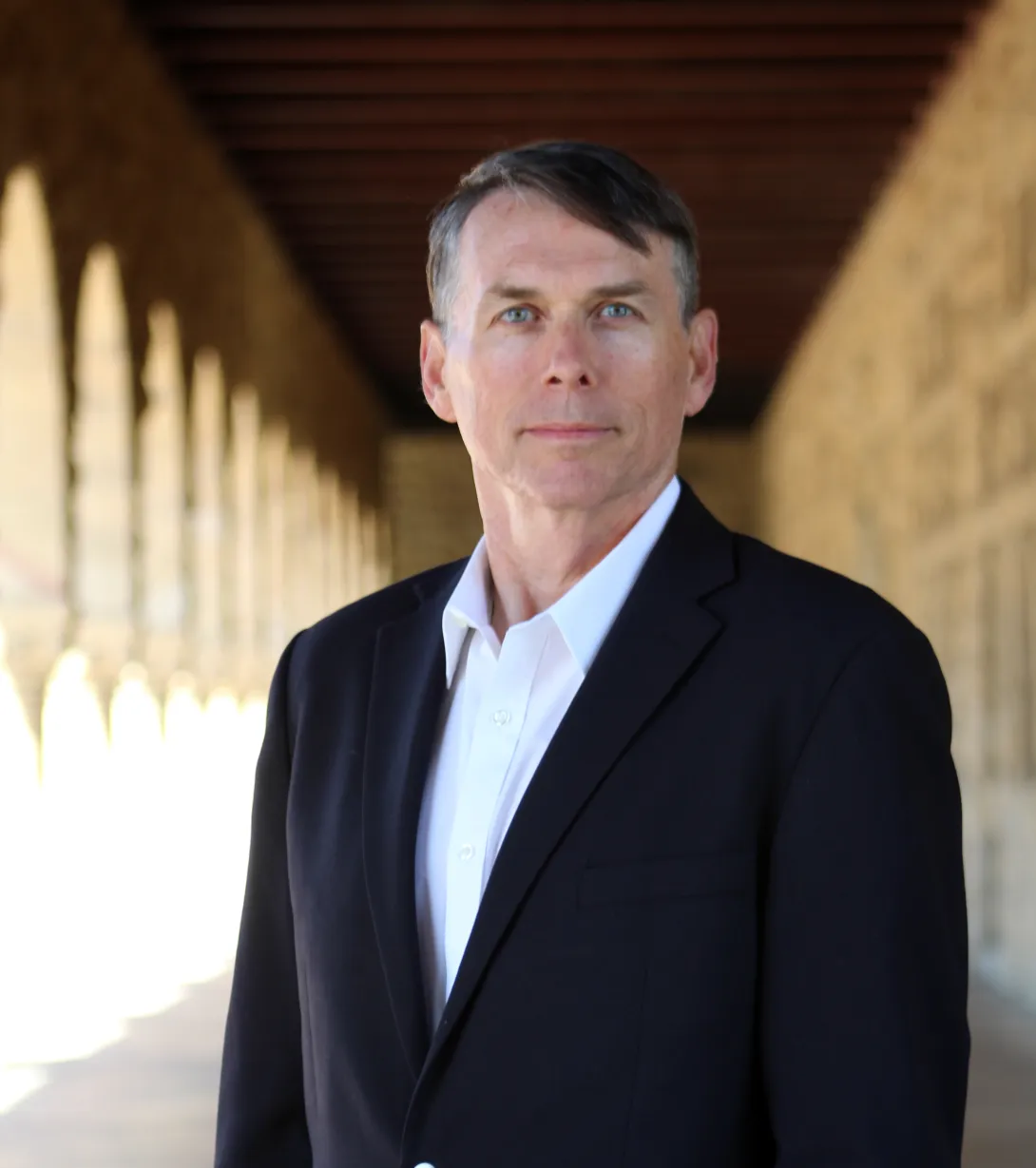 Professor Thomas Dee in front of Stanford Quad arches